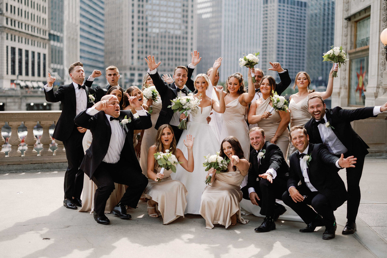 Wedding party posing in front of a cityscape with buildings.