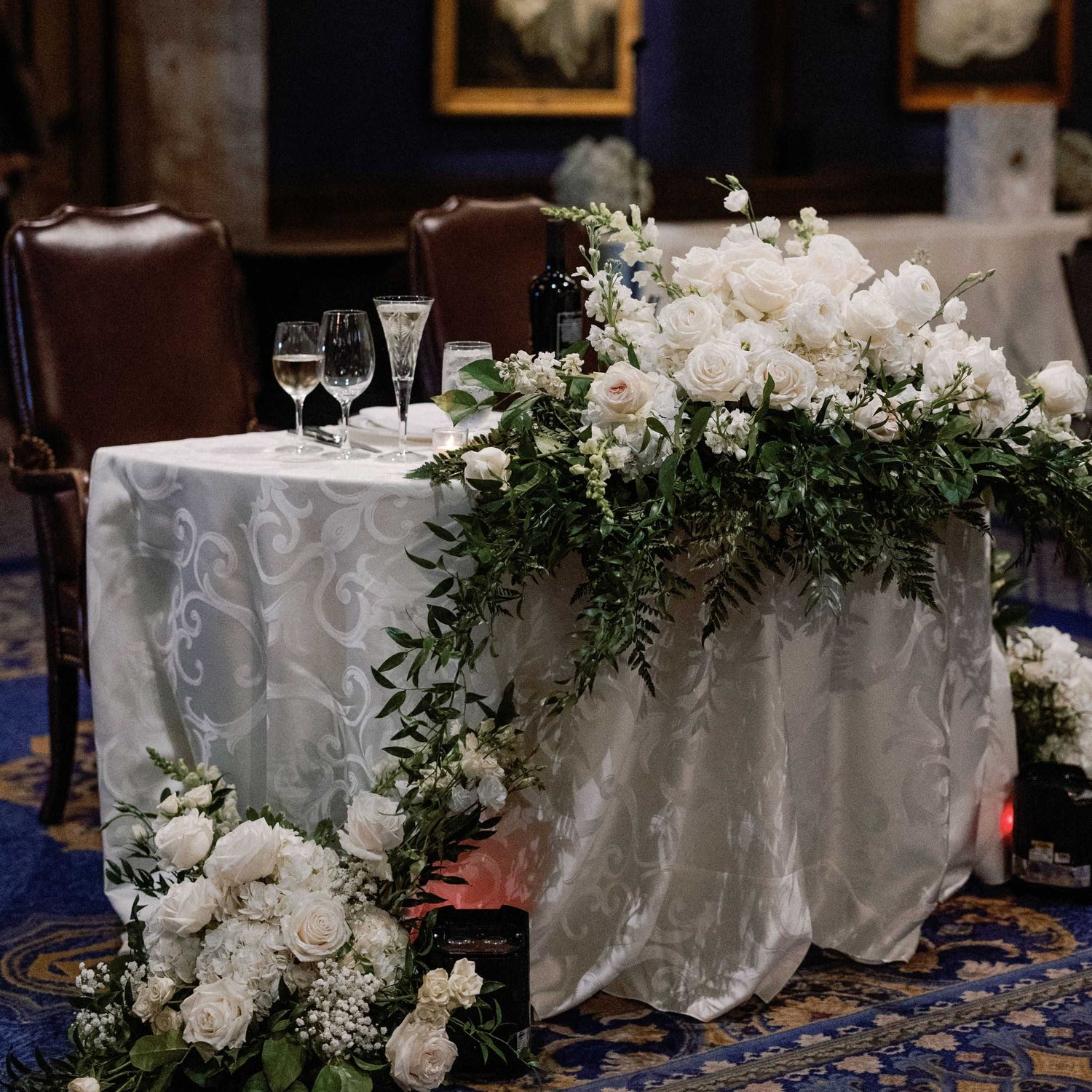 Decorated table with white flowers and greenery in a formal setting